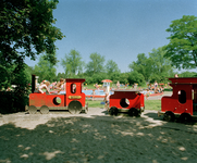 823855 Afbeelding van een speeltoestel in de vorm van een treintje op de speelweide van Aquacenter Den Hommel ...